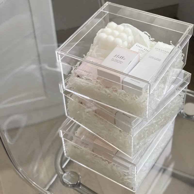 Stacked clear acrylic gift boxes with products inside