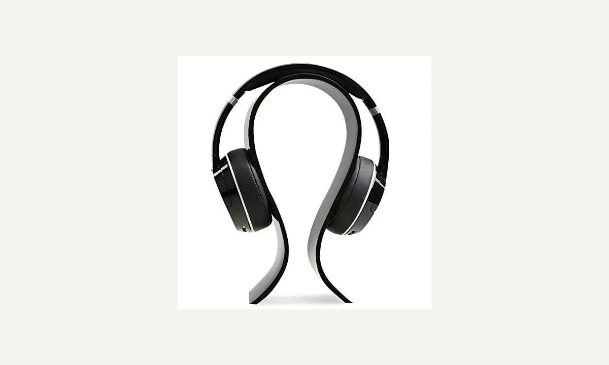 Curved black headphone stand with a headset resting on its upper support.