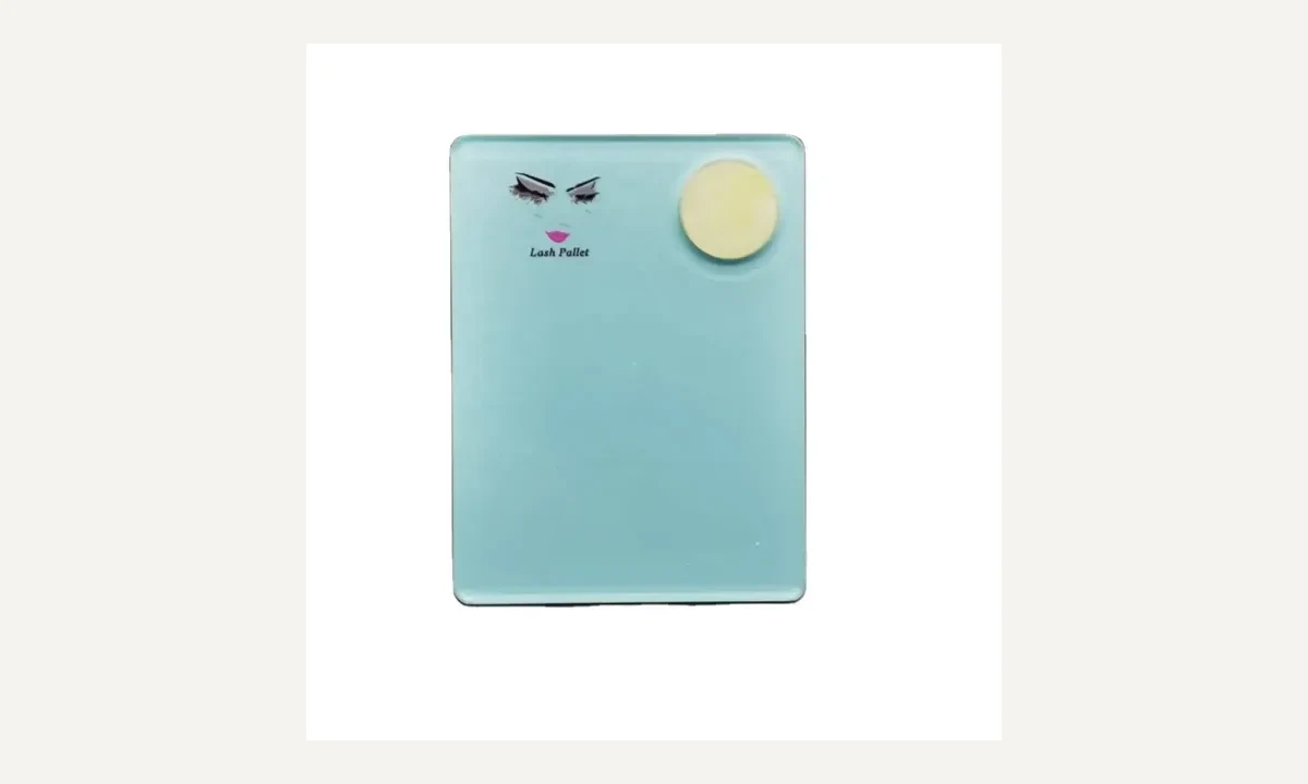 Rectangular lash palette shown with small printed artwork and a separate round glue stone.