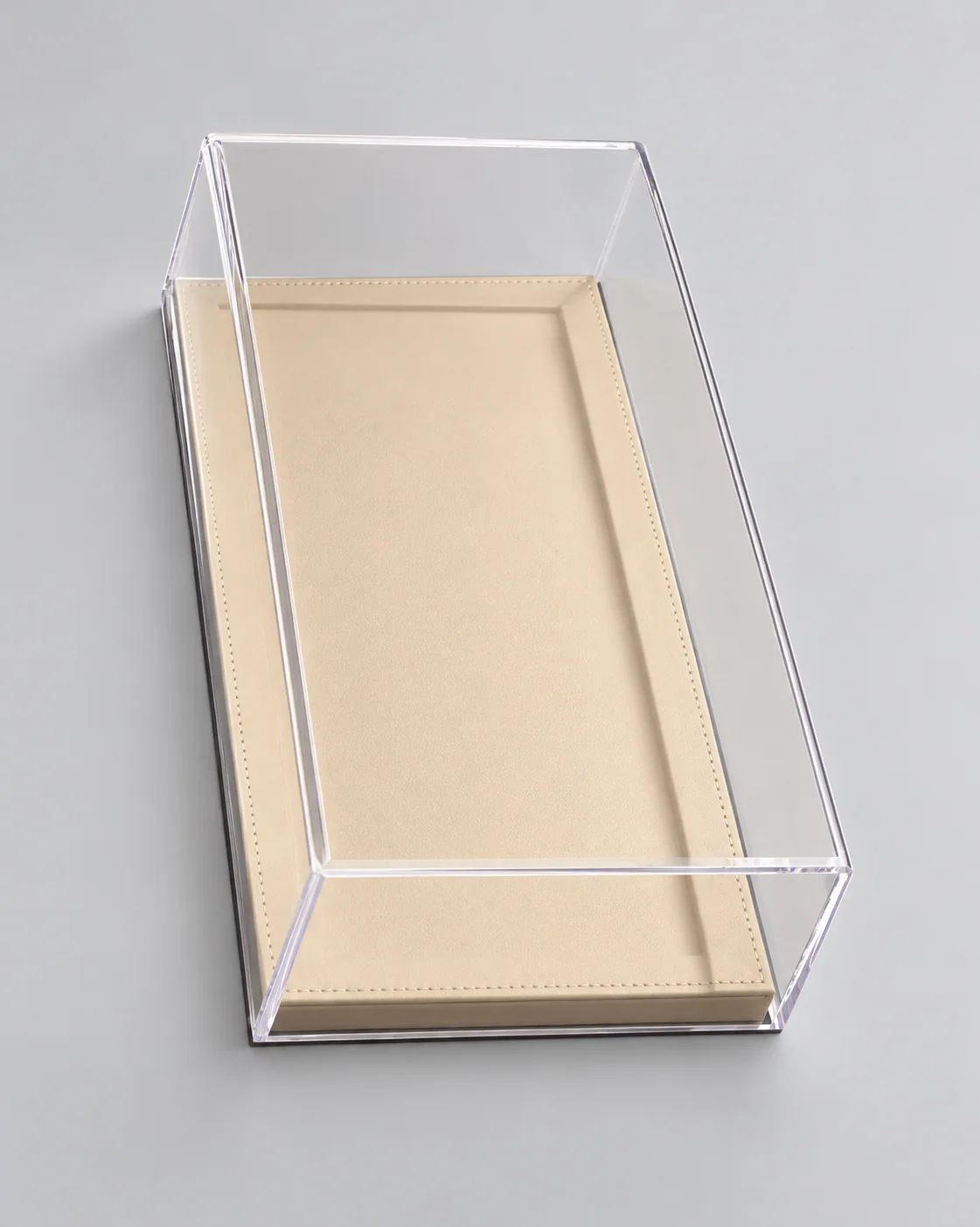 Retouched reference photo of an empty clear acrylic display cover on a beige rectangular base