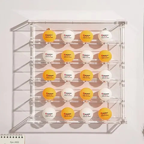 Tall clear golf-ball display cabinet filled with yellow and white balls