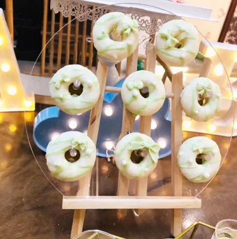 Upright wooden peg board displaying ring donuts in rows