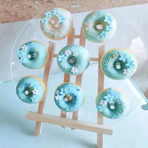 Upright wooden peg board displaying ring donuts in rows
