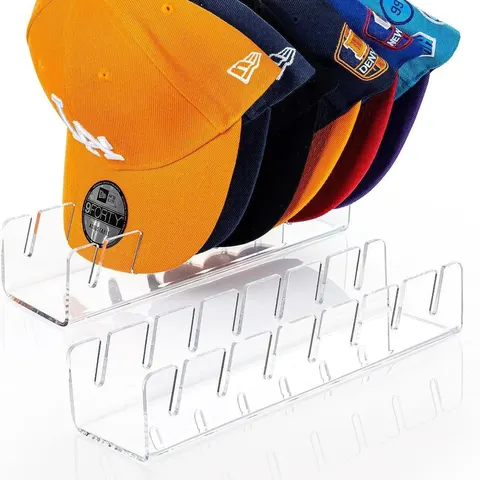 Slotted acrylic cap organizer holding cap brims in a row