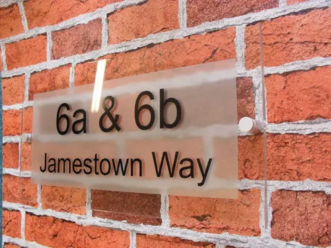 Printed acrylic door sign mounted with metal standoff-style fixings