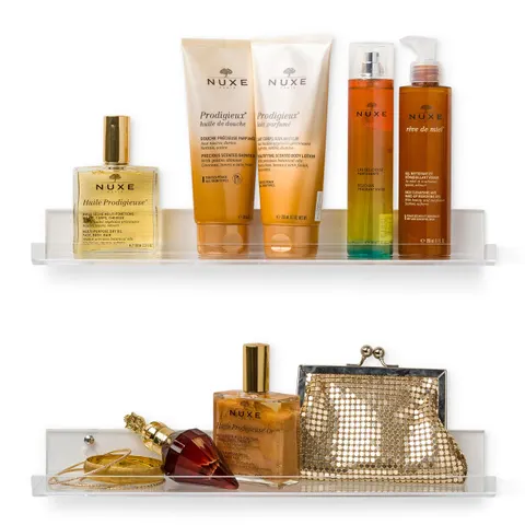 Wall-mounted acrylic shelves displaying bottles and a small handbag